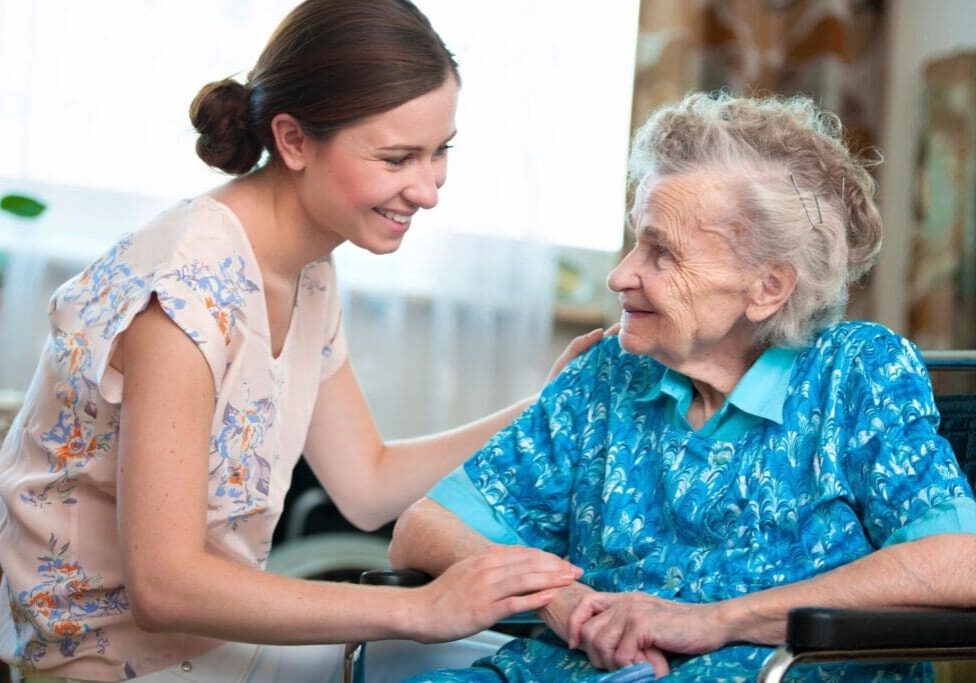 A woman holding hands with an older person.