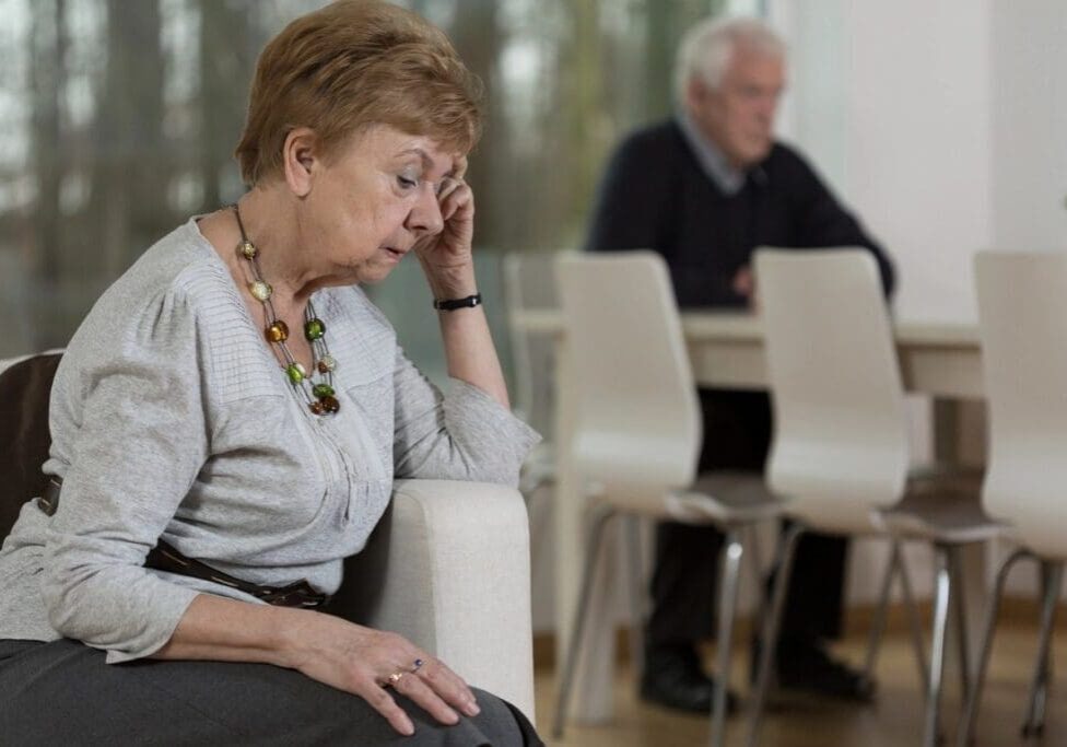 A woman sitting on the ground with her head down.