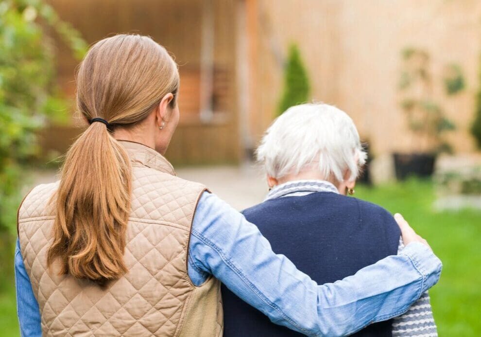 A woman and an old man are standing outside